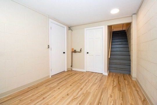 Lower level with stairs and door to the garage